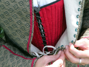 The lacing rings are visible here. If the jacket is very tight, all rings are neaded to avoid gapping in the front; it is fairly loose on me, so I lace up with every other ring. The fabric stretches quite a bit and molds well to the body with few wrinkles, even when it's laced tight.