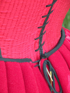 point laces through two holes on either side of the petticoat's back opening. This allows for considerable adjustability. Also, when the laces are tied together after being threaded through both sets of holes, they stay laced remarkably well--it takes work to loosen the hitch.