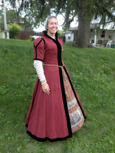 The gown is russet wool lined with brown linen. It hooks up the front with hooks and eyes.